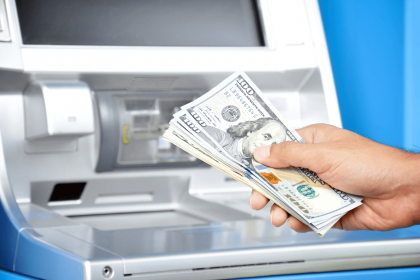 Hand holding cash withdrawn from an ATM