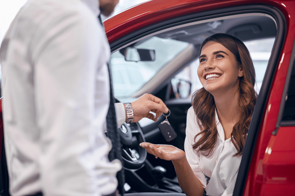 Woman receiving car keys for a new car