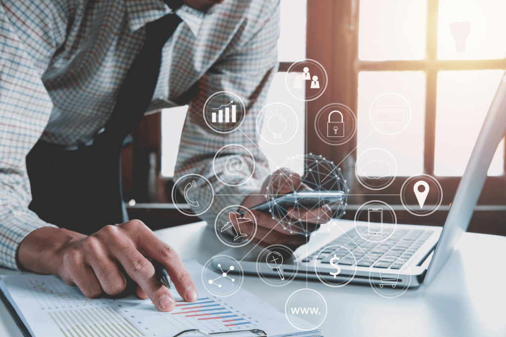 A person analyzing financial data with a smartphone and a laptop.