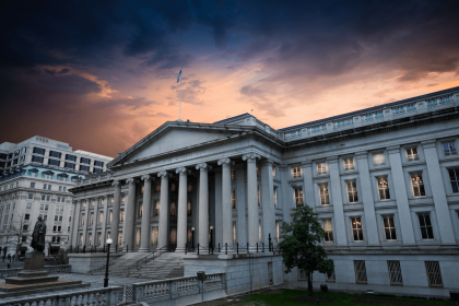 The Treasury Department building with a dramatic sunset sky, representing the US Federal Reserve's approval for the 2024 dollar supply to the Central Bank of Iraq.