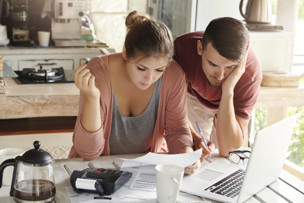 Couple planning their budget with a laptop and documents.