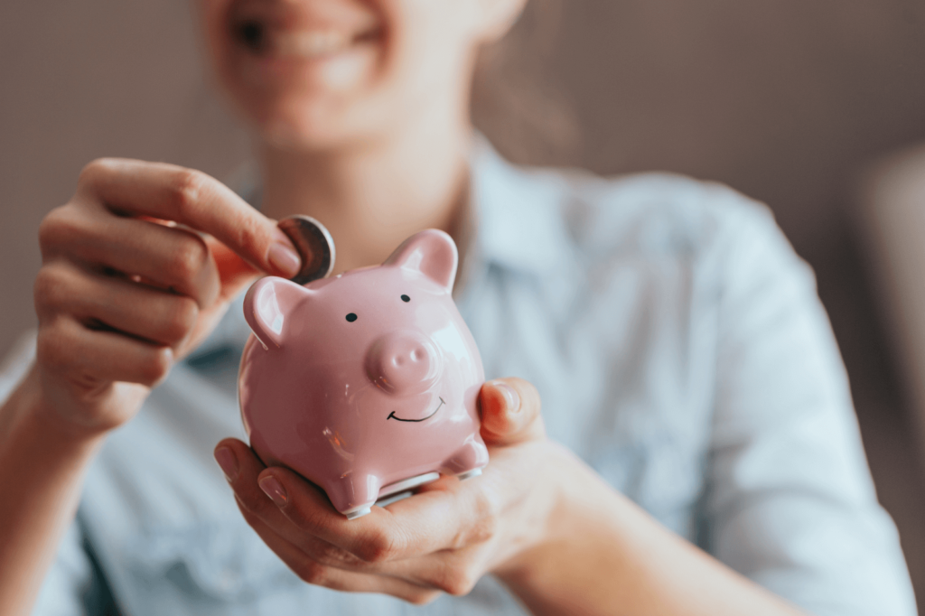 Person saving money in a piggy bank.