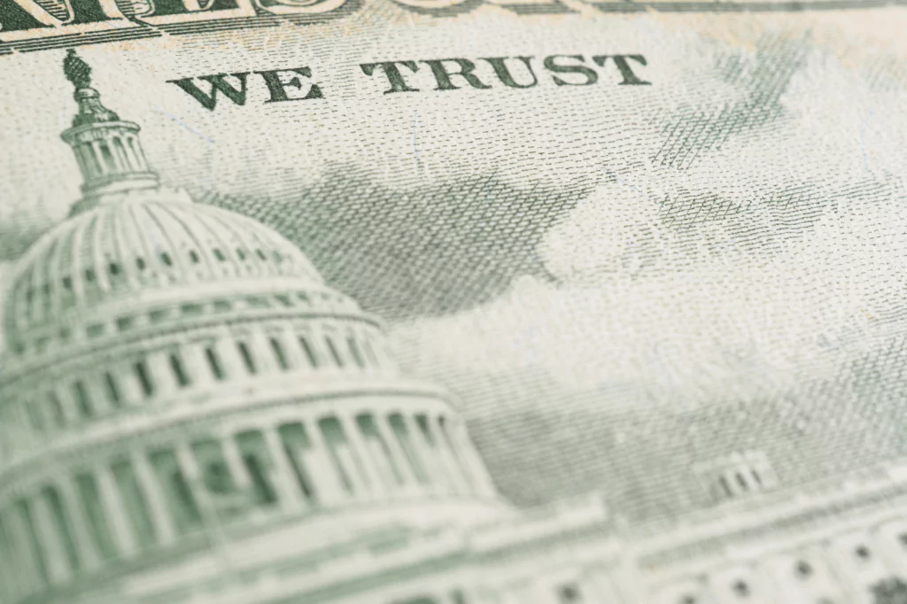 Close-up of the Capitol building on a dollar bill with the words In God We Trust.