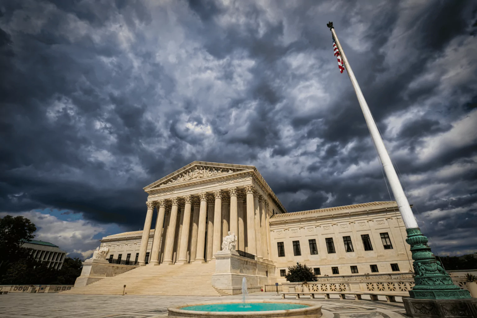 Supreme Court building with dark clouds, symbolizing a landmark decision.