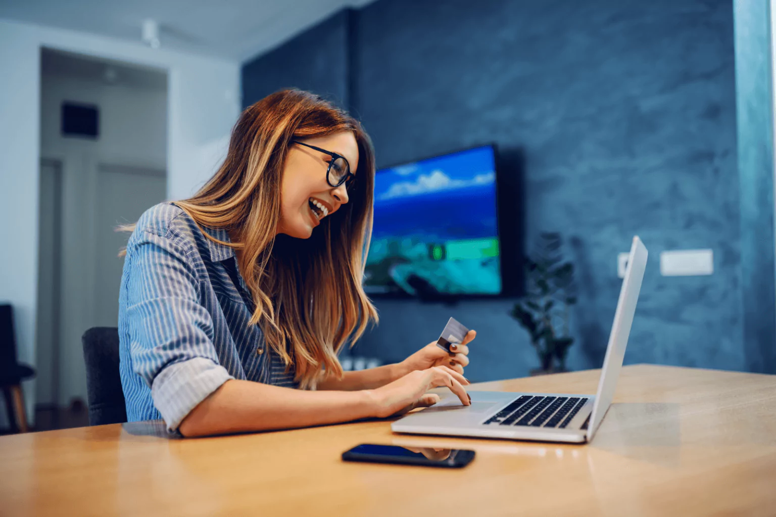 Woman using online banking on her laptop with a credit card