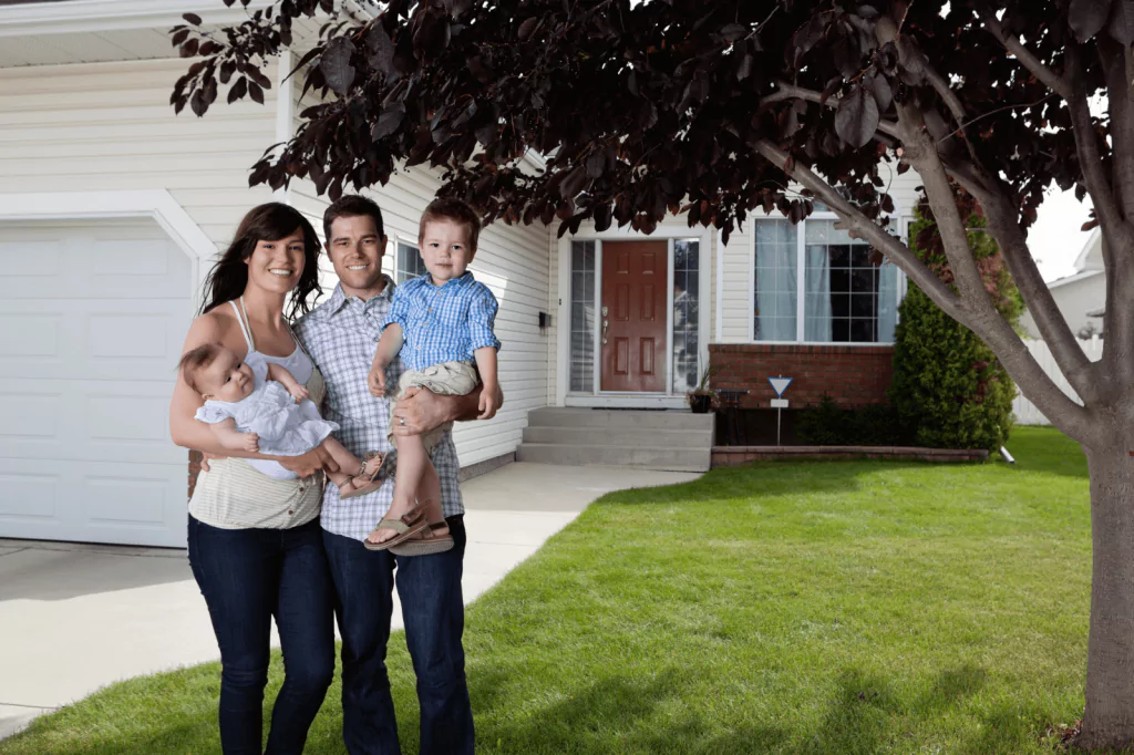 Young family in front of their new home