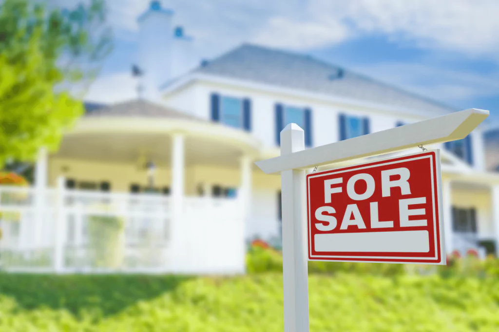 House with a 'For Sale' sign in the yard