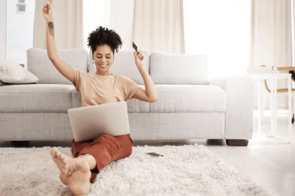 Person celebrating with a laptop and credit card