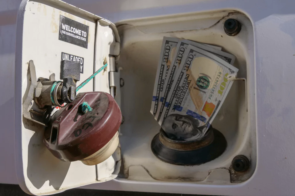 Gas cap with money inside, symbolizing the financial impact of falling gas prices