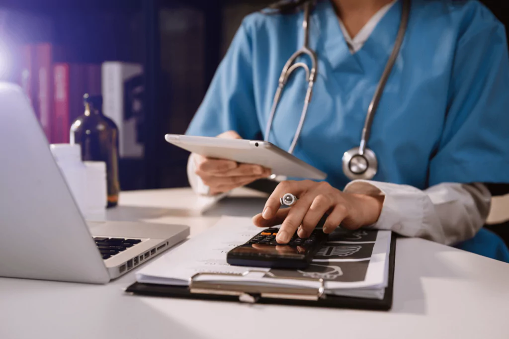 Doctor using a tablet and calculator